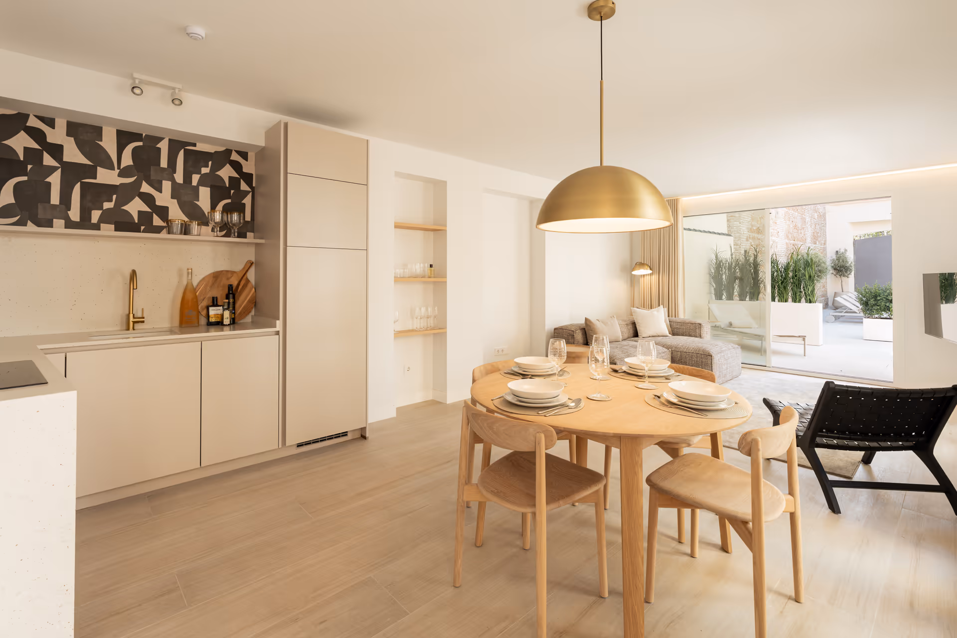 Open-plan living and dining area in the Toro residence, with a modern kitchen and sliding doors opening onto a private terrace