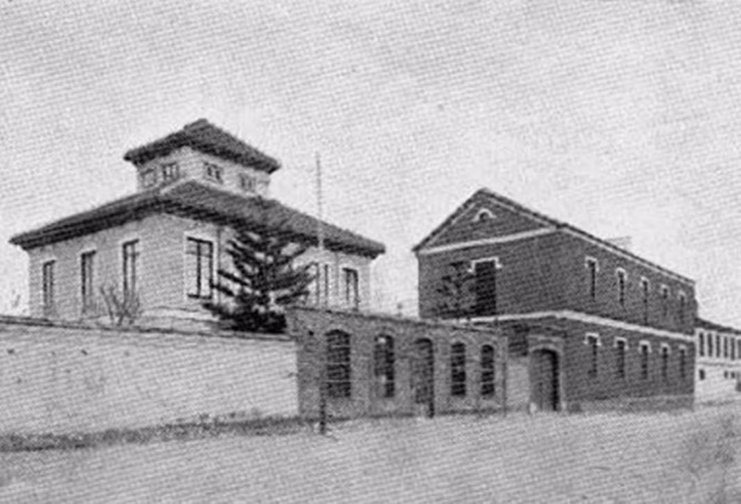 An early twentieth-century black and white view of the original villa, showing its tower and the adjacent industrial buildings