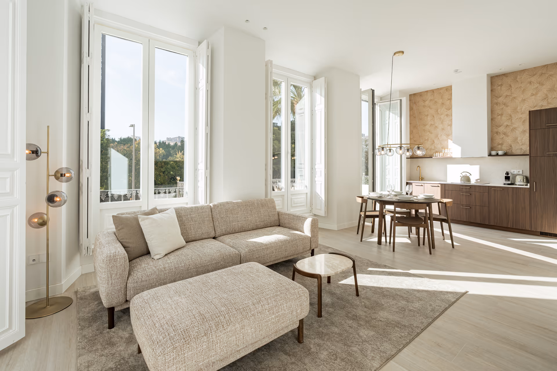 The bright, open-plan living area of the Aurum residence, with a textured sofa, wooden dining set, and modern kitchen