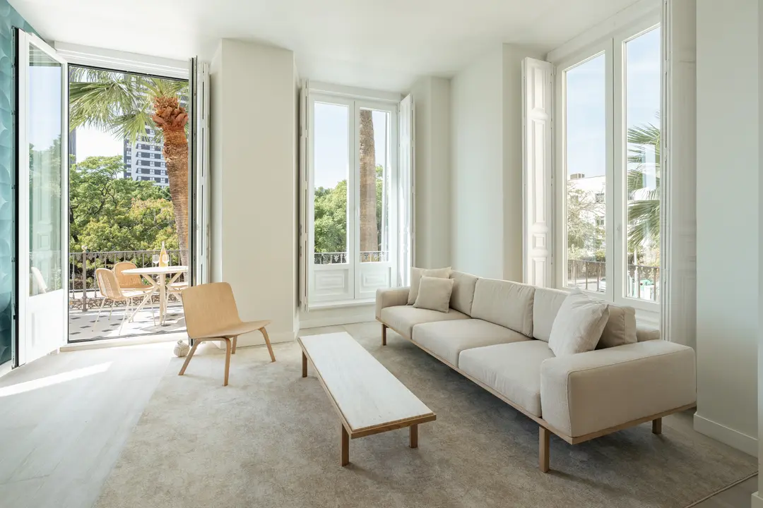 Bright living room in the Azuri residence with a beige sofa, low coffee table, and doors opening onto a balcony