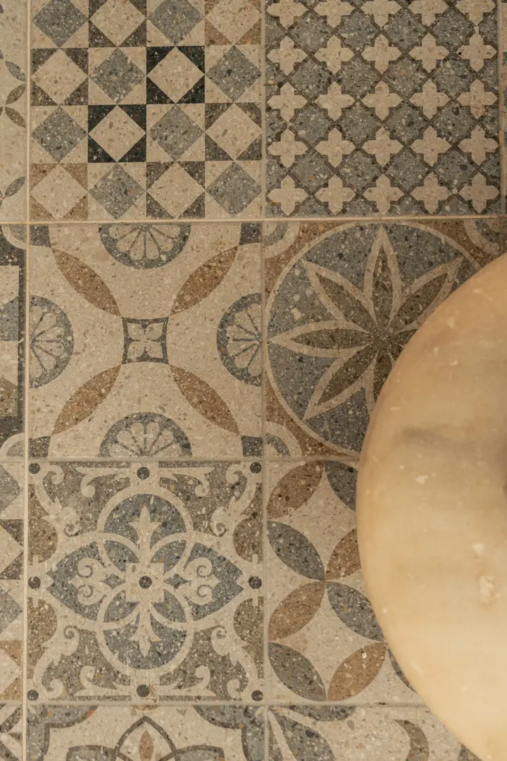 Close-up of the traditional patterned floor tiles in the entrance hall beside the original 1908 marble staircase base
