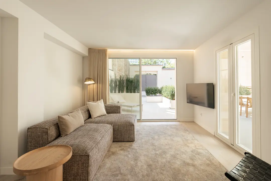 Bright living room in the Toro residence with a large brown corner sofa and sliding doors to a private terrace