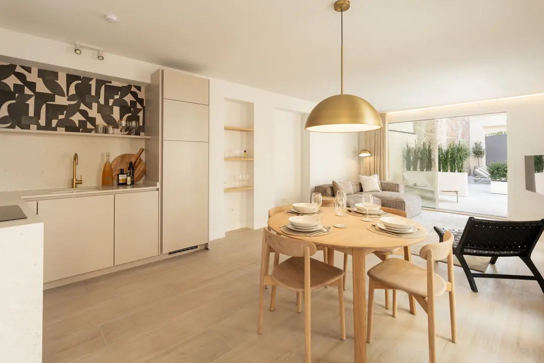 Open-plan living and dining area in the Toro residence, with a modern kitchen and sliding doors opening onto a private terrace
