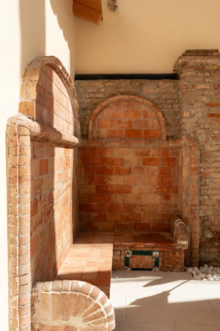 A built-in terracotta brick bench with an arched back on the private terrace of the Vino residence at Palacete 10